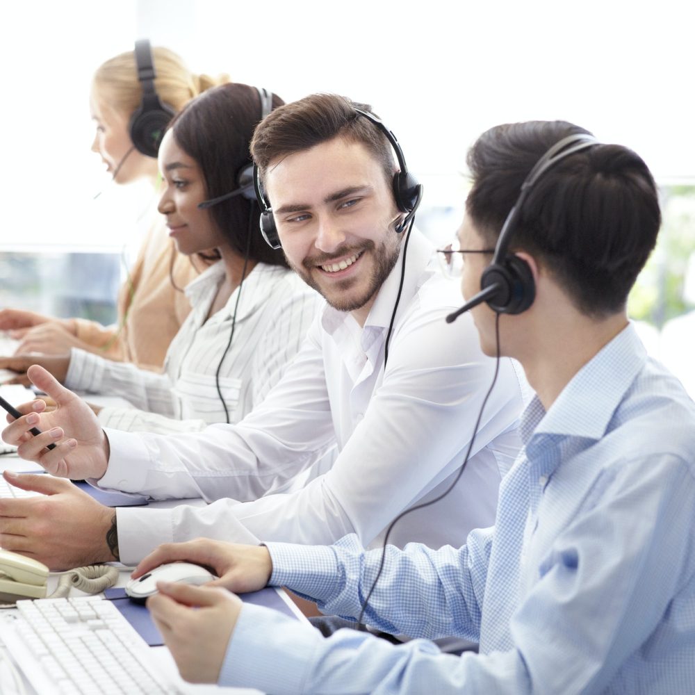 Happy male technical support operators having friendly chat at call centre